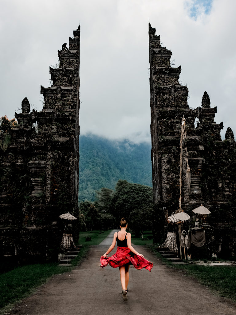 Une femme avec une jupe rouge court vers un temple