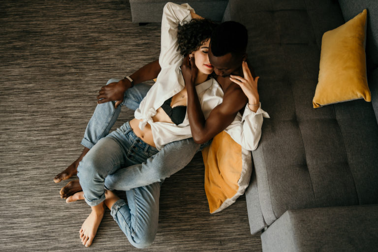 Un homme et une femme assis au sol et s'enlaçant pendant leur séance photo de couple