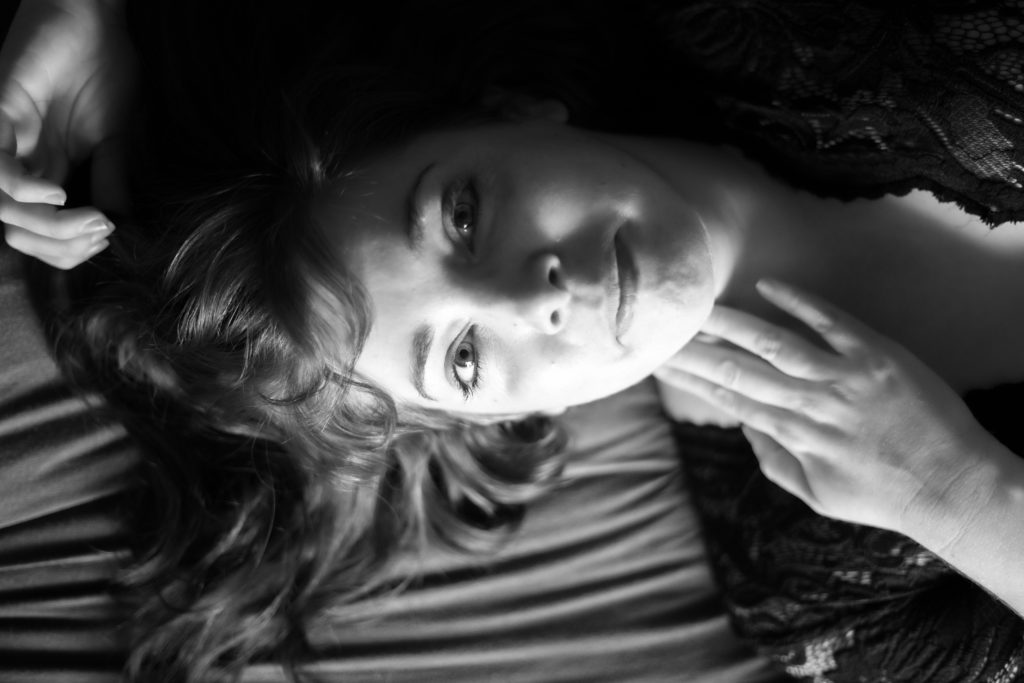 Portrait en noir et blanc d'une femme allongée sur un lit