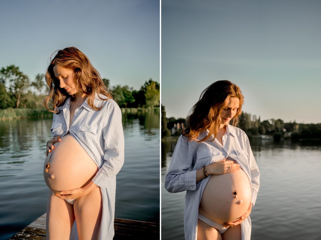 Femme enceinte portant une robe longue ouverte sur son ventre lors d'une séance photos de maternité dans un lac
