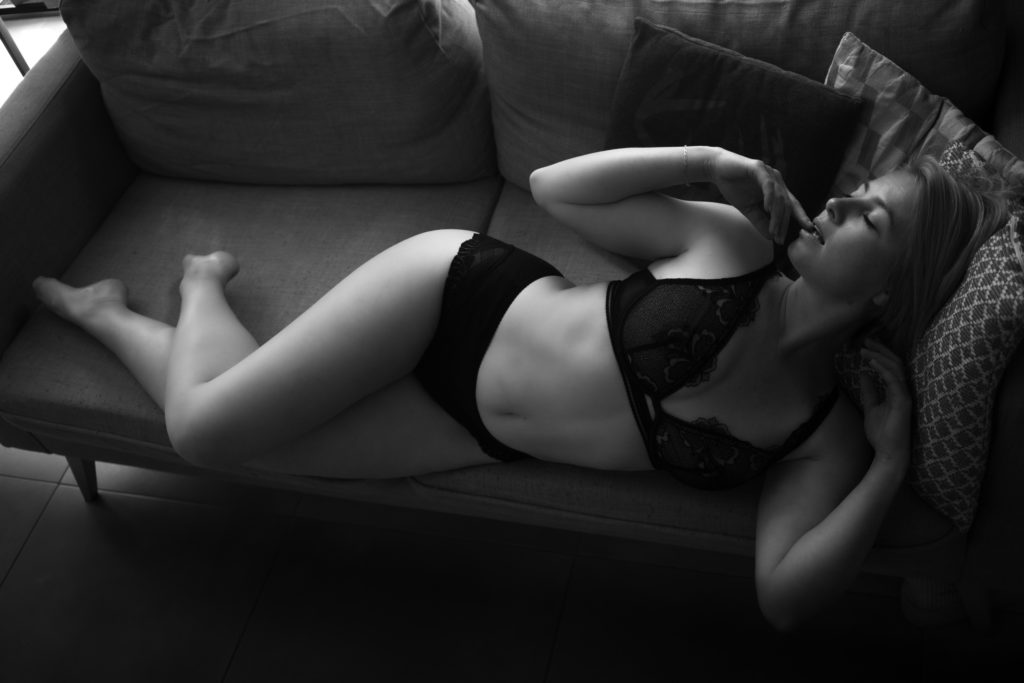 Photo en noir et blanc d'Emmanuelle allongée langoureusement sur son canapé.